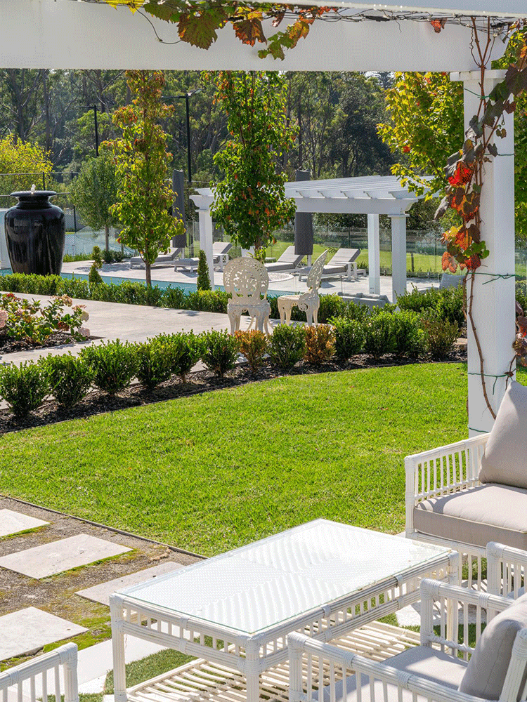 Landscaped acreage garden overlooking a pool, pergola and surrounding bushland