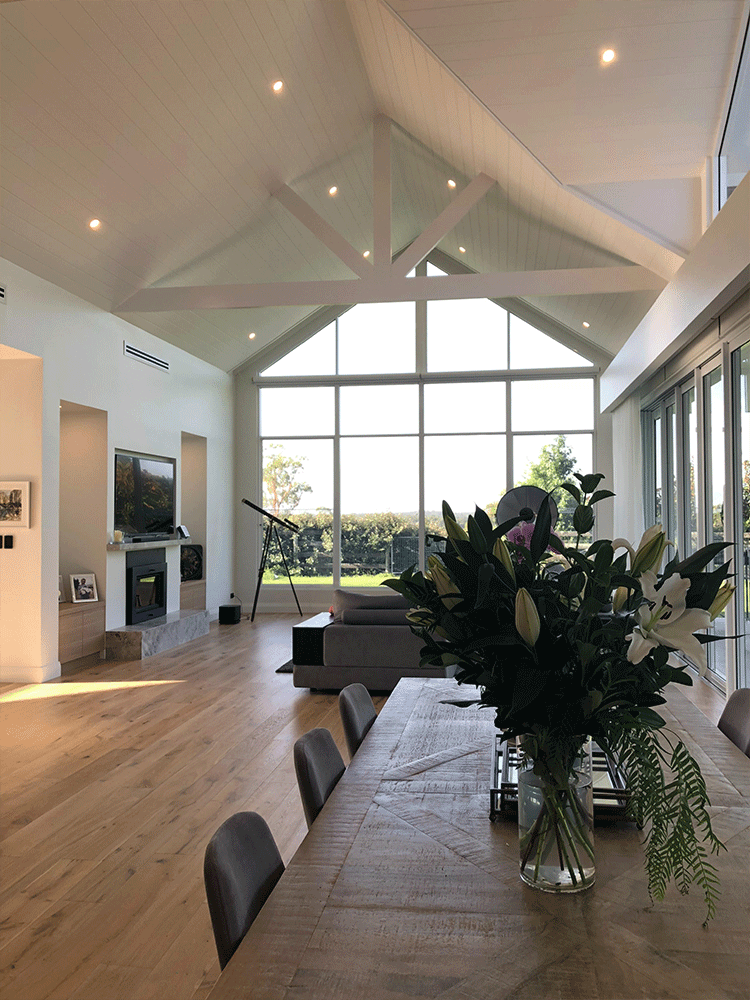 Vaulted open-plan living and dining room with exposed beams and garden views