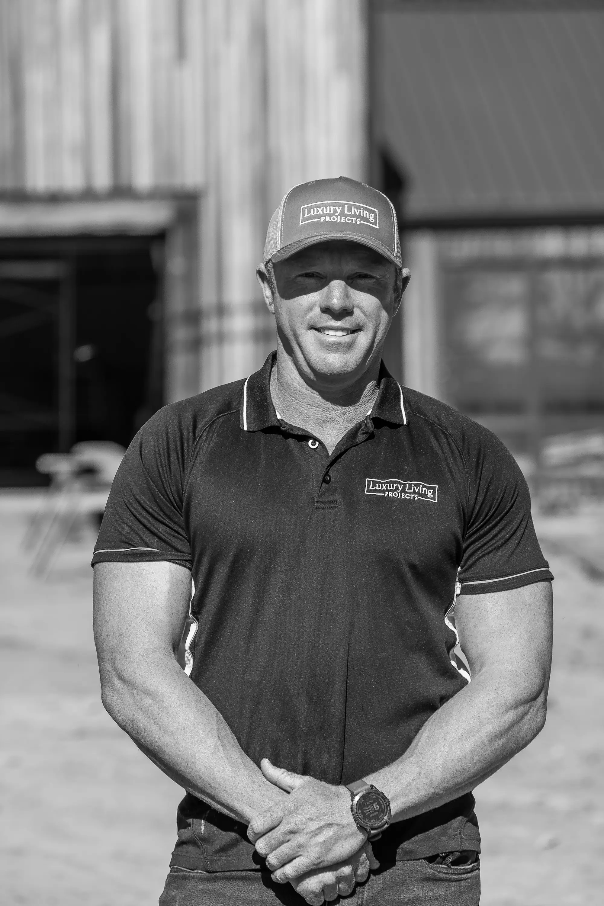 Black and white portrait of Daniel Whitehead on site in a Luxury Living Projects polo shirt and cap