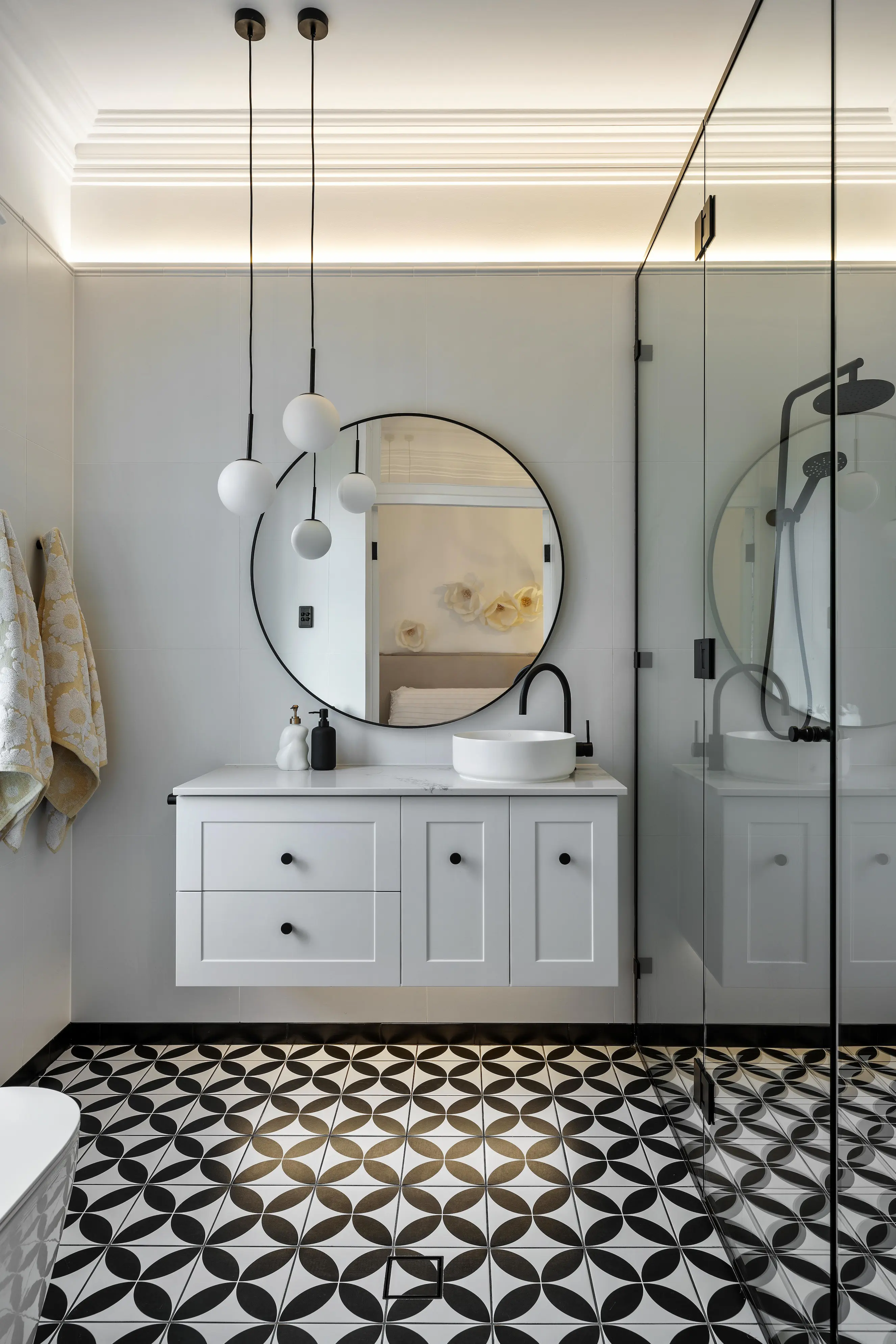 Bathroom vanity with vessel sink, round mirror and geometric floor tiles