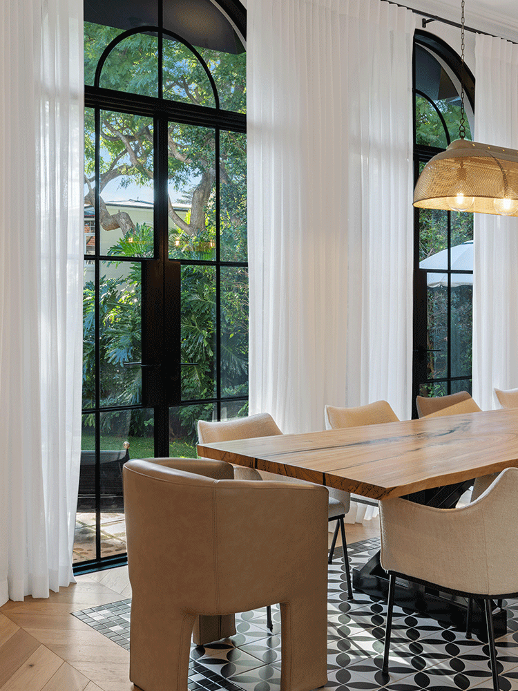 Renovated dining room with arched black-framed windows and sheer curtains